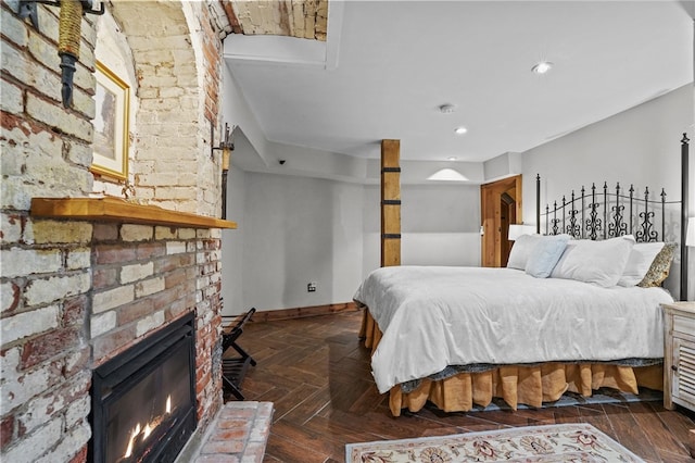 bedroom featuring a fireplace and dark parquet floors