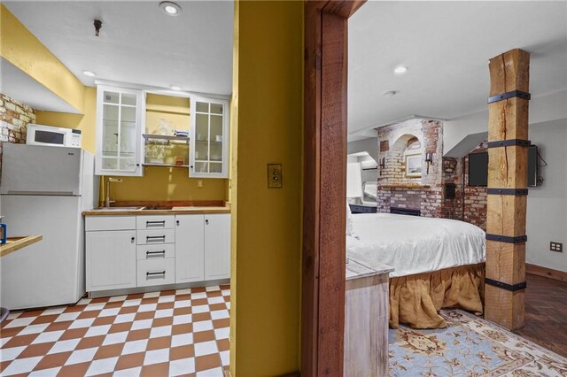 43 Old Beach Rd, Newport, RI 02840 - kitchen featuring white appliances, white cabinets, tile patterned floors, glass insert cabinets, and a sink
