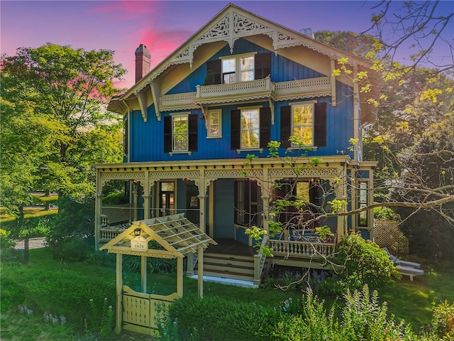 back house at dusk with covered porch