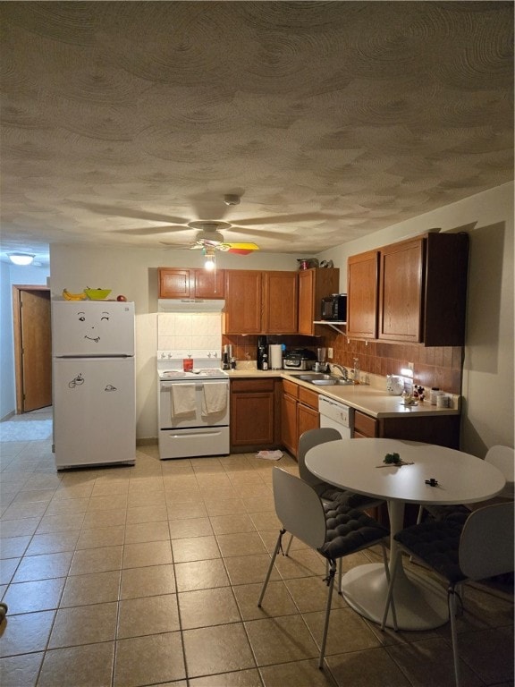 kitchen with ceiling fan, sink, tasteful backsplash, white appliances, and light tile patterned flooring