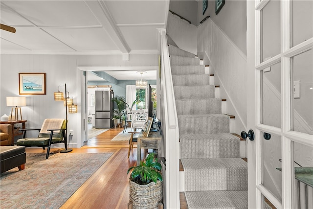 stairs with hardwood / wood-style flooring and ornamental molding