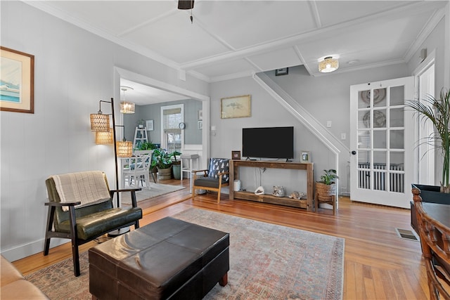 living room featuring hardwood / wood-style floors, ceiling fan with notable chandelier, and ornamental molding