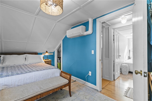 bedroom featuring light hardwood / wood-style floors and a wall unit AC