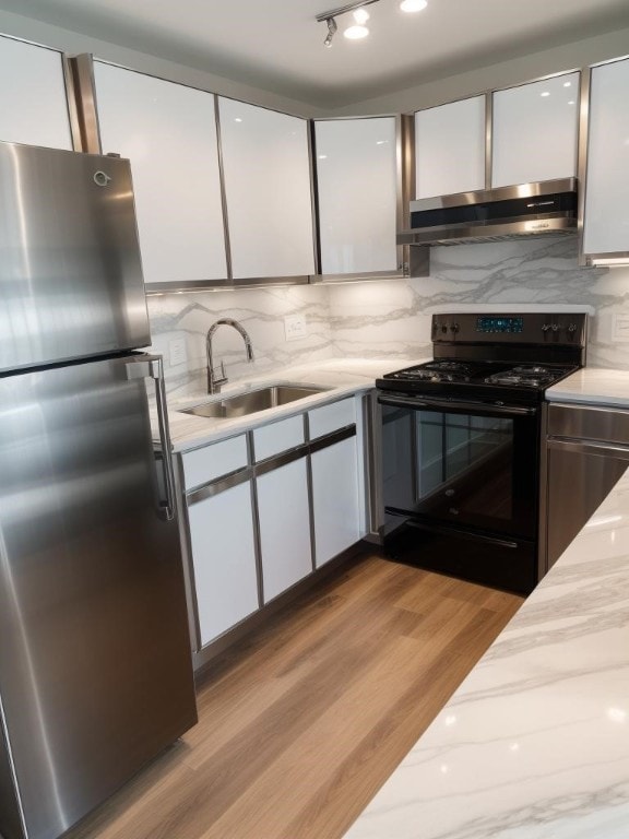 kitchen featuring ventilation hood, white cabinets, sink, stainless steel fridge, and black range with electric cooktop