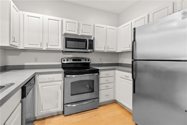 kitchen featuring stainless steel appliances, white cabinetry, and light wood-type flooring