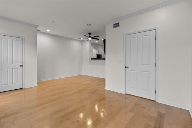 spare room with crown molding, ceiling fan, and light wood-type flooring