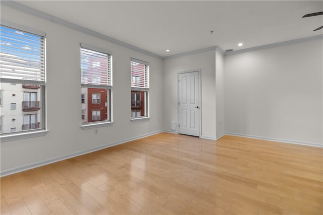 empty room with crown molding and light wood-type flooring