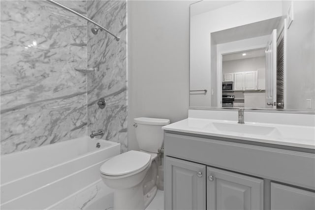 full bathroom featuring tiled shower / bath combo, vanity, and toilet