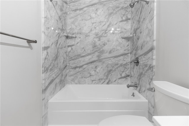 bathroom featuring tiled shower / bath and toilet