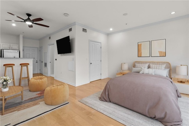 bedroom featuring crown molding, ceiling fan, refrigerator, and light wood-type flooring