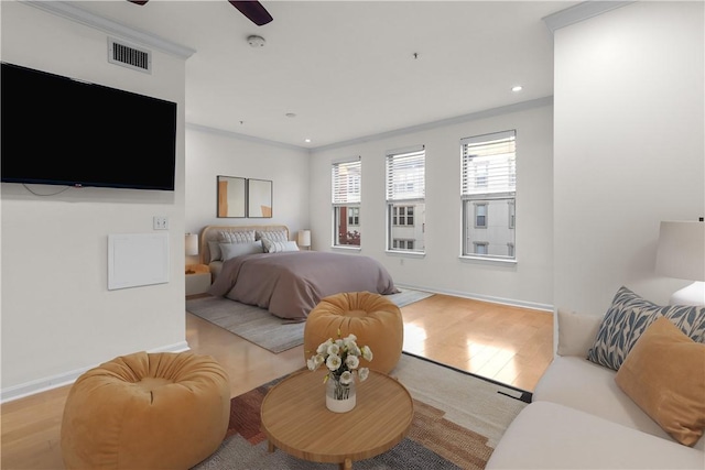 bedroom featuring crown molding and light hardwood / wood-style flooring