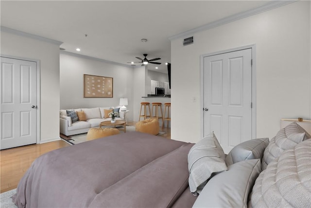 bedroom with crown molding and light hardwood / wood-style floors