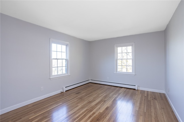 unfurnished room featuring light hardwood / wood-style floors and a baseboard radiator