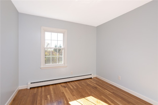 spare room with baseboard heating and light wood-type flooring