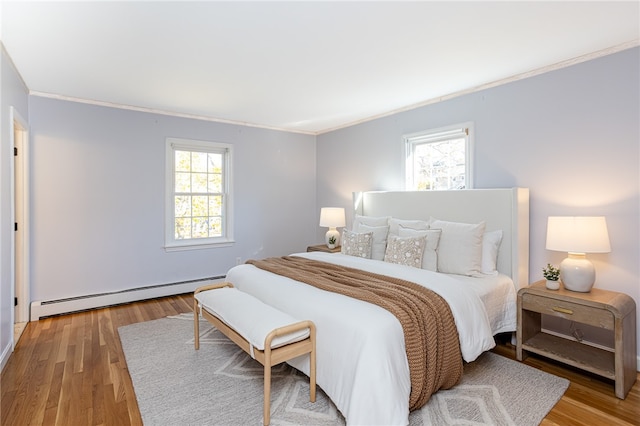 bedroom featuring multiple windows, crown molding, a baseboard radiator, and light hardwood / wood-style floors