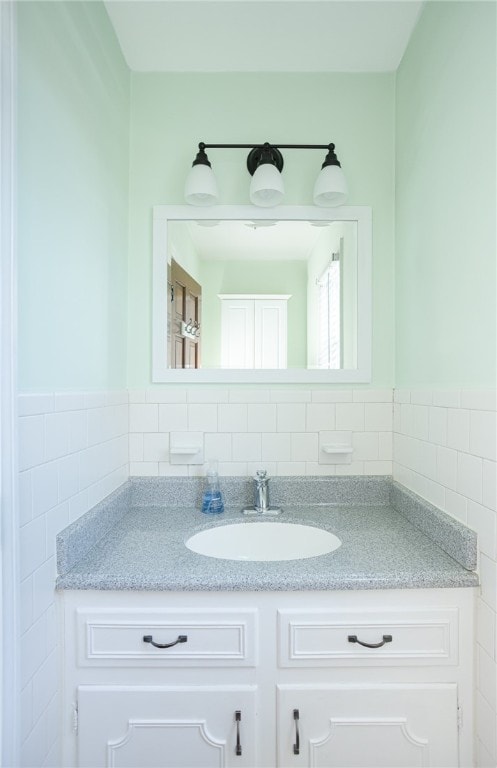 bathroom with vanity and tile walls