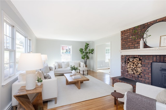 living room with hardwood / wood-style floors, a brick fireplace, baseboard heating, and ornamental molding