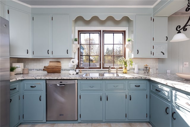 kitchen with sink, hanging light fixtures, light stone counters, decorative backsplash, and appliances with stainless steel finishes