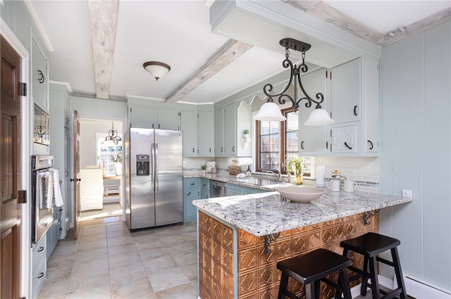 kitchen with pendant lighting, appliances with stainless steel finishes, beam ceiling, light stone counters, and kitchen peninsula