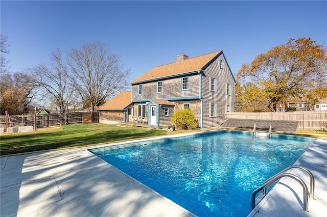 view of pool featuring an outdoor structure, a patio area, and a yard