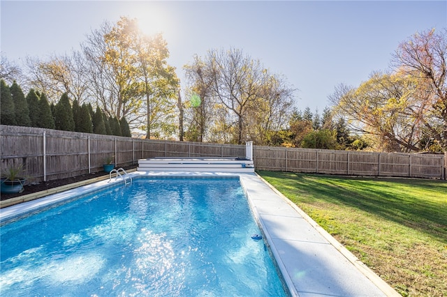 view of pool with a lawn