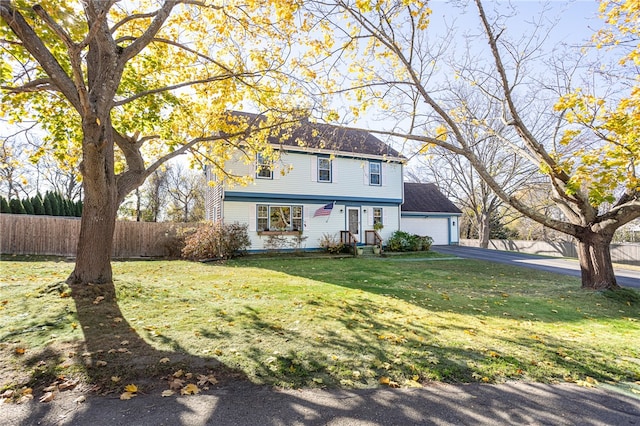 colonial inspired home featuring a front lawn and a garage