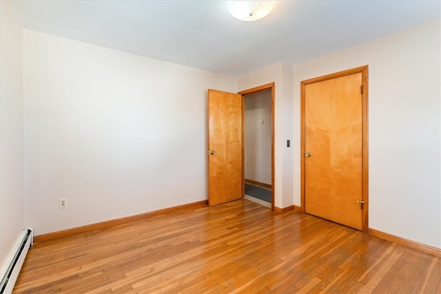 spare room with light wood-type flooring and a baseboard radiator