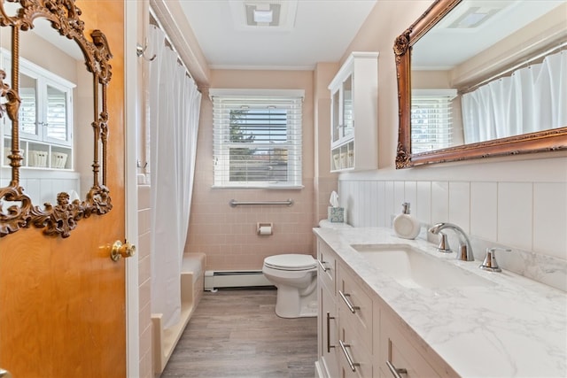 full bathroom with hardwood / wood-style floors, vanity, a healthy amount of sunlight, and a baseboard heating unit