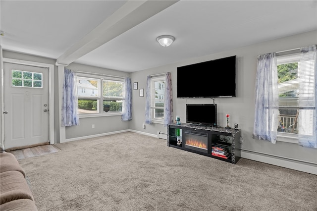 carpeted living room featuring beamed ceiling, baseboard heating, and plenty of natural light