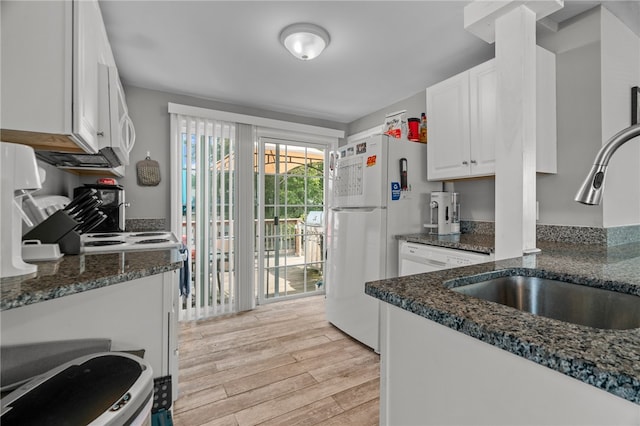 kitchen featuring dark stone counters, sink, white cabinets, and light hardwood / wood-style floors