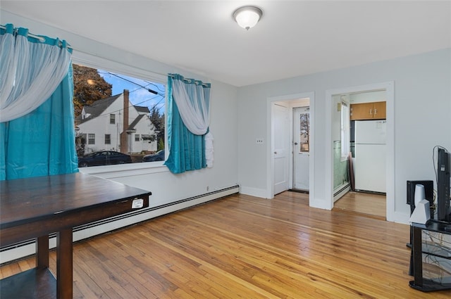 interior space with hardwood / wood-style floors and a baseboard heating unit