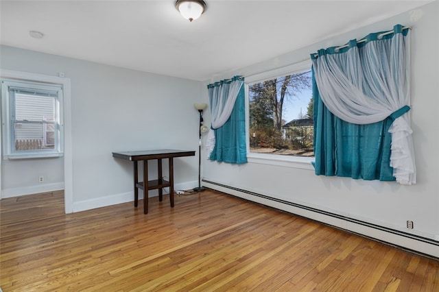 spare room with hardwood / wood-style flooring and baseboard heating