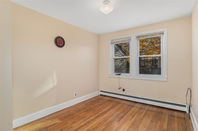 spare room with baseboard heating and hardwood / wood-style floors