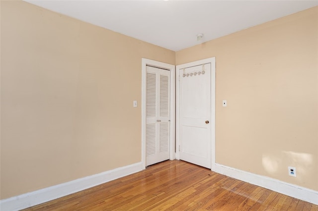 unfurnished bedroom with wood-type flooring and a closet