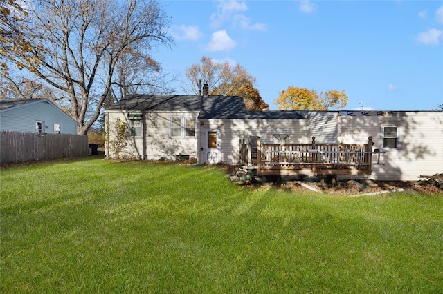 rear view of house featuring a lawn and a deck