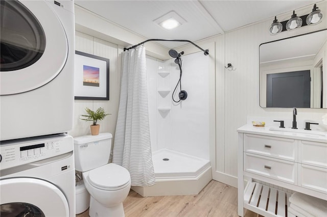 bathroom with hardwood / wood-style flooring, curtained shower, vanity, and stacked washer / drying machine