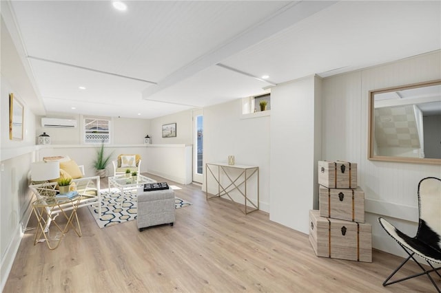 living room with a wall mounted AC, light wood-type flooring, and a wealth of natural light