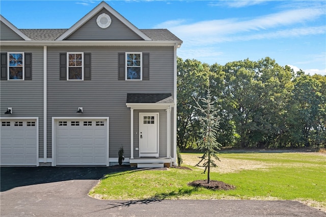 front facade with a front yard and a garage