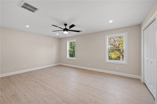 unfurnished bedroom with multiple windows, ceiling fan, a closet, and light wood-type flooring