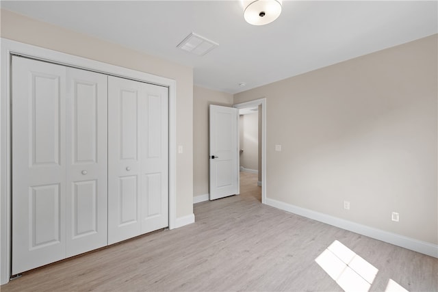 unfurnished bedroom featuring a closet and light hardwood / wood-style flooring