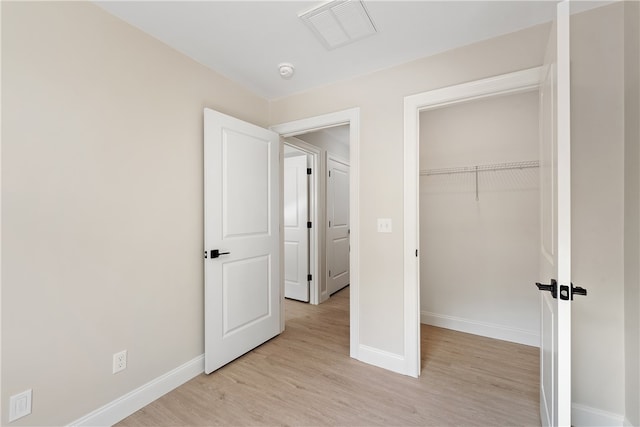 unfurnished bedroom with light hardwood / wood-style flooring and a closet