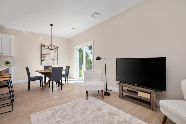 living room featuring light hardwood / wood-style floors and an inviting chandelier