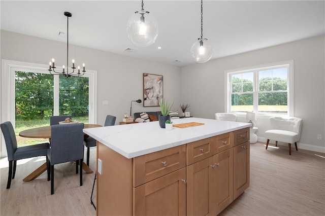 kitchen featuring a notable chandelier, a center island, hanging light fixtures, and light hardwood / wood-style flooring