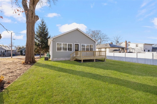 rear view of property featuring a lawn and a wooden deck