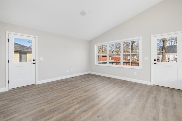 entryway with light wood-type flooring, plenty of natural light, and lofted ceiling