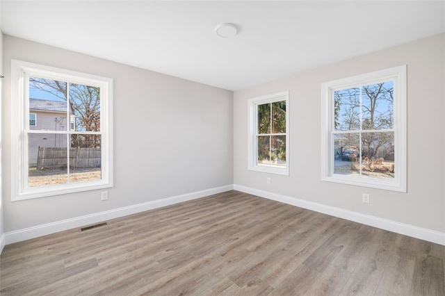 spare room with a healthy amount of sunlight and light hardwood / wood-style floors