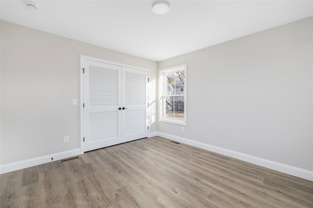 unfurnished bedroom with a closet and light hardwood / wood-style floors