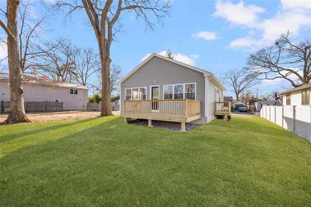 rear view of house featuring a lawn and a wooden deck