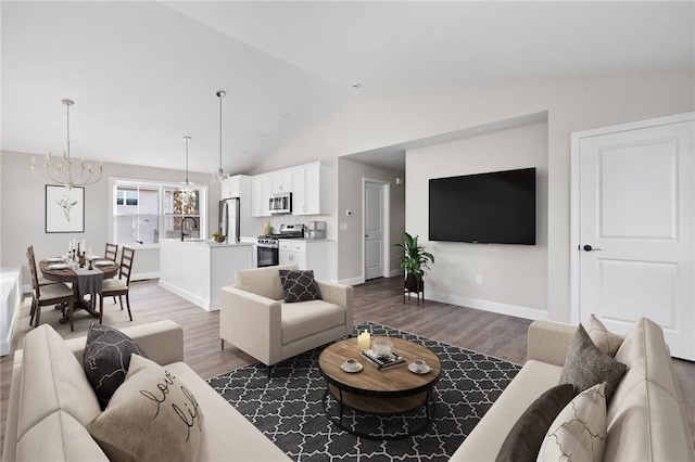 living room featuring sink, dark hardwood / wood-style flooring, lofted ceiling, and a notable chandelier