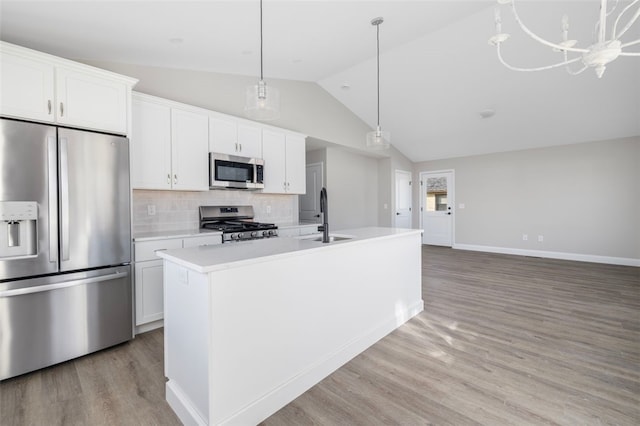 kitchen featuring lofted ceiling, a kitchen island with sink, white cabinets, sink, and stainless steel appliances